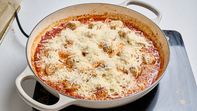 meatballs in sauce topped with cheese