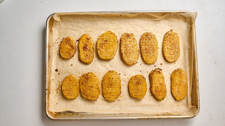 partially baked potatoes on a sheet tray