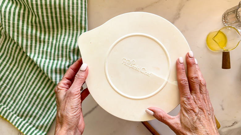Hands placing lid onto bowl