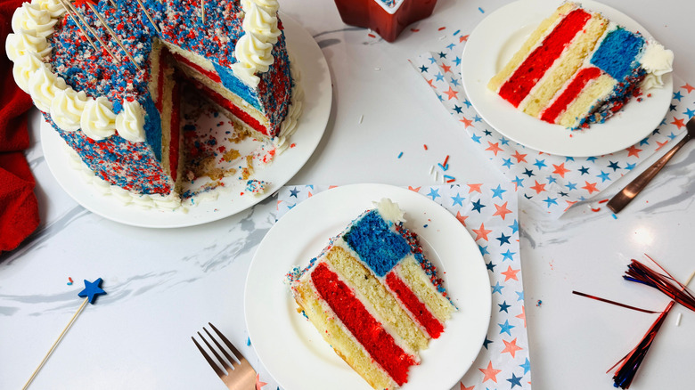 American flag cake slices on plates next to whole cake