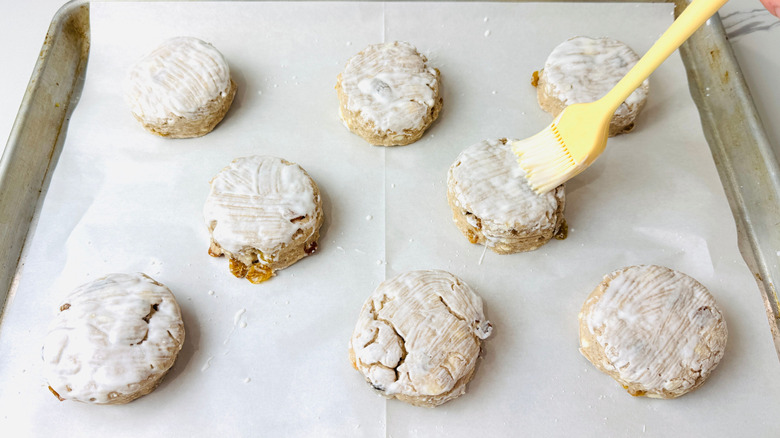 Pastry brush brushing buttermilk onto biscuits