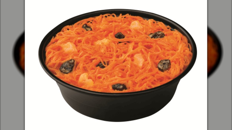 Carrot raisin salad in a black plastic bowl