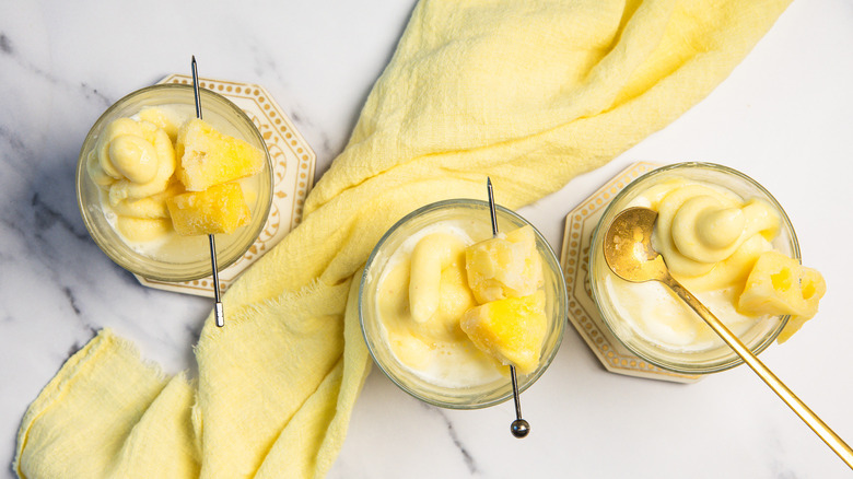 Three glasses of Dole Whip float with spoons.