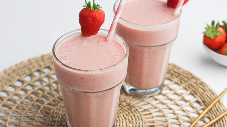 Strawberry smoothies with straws and strawberry garnish