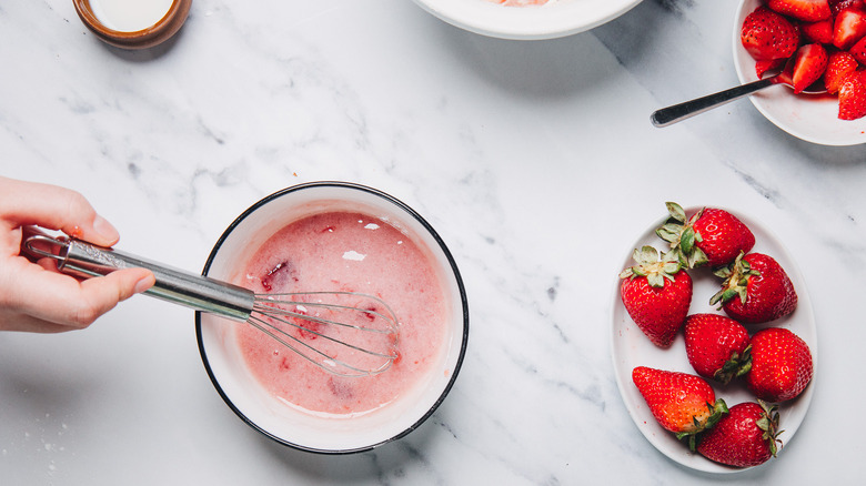 Whisking strawberry glaze in small bowl.