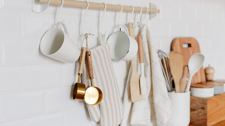 Measuring cups and utensils hanging from railing