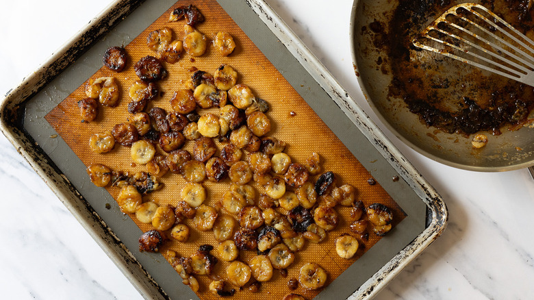 Flambeed bananas on baking sheet, and besides pan with bourbon drippings.