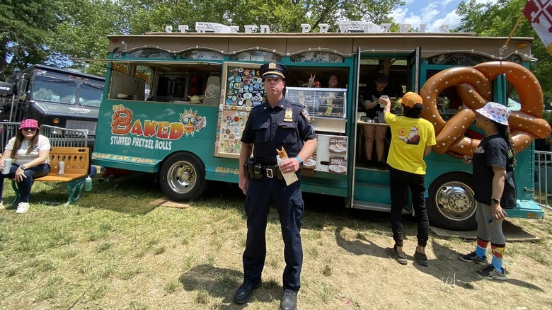 A policeman stood with food outside of a food vendor at Governor's Ball festival