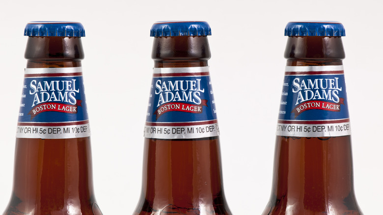 Necks of three bottles of Sam Adams beer on white background