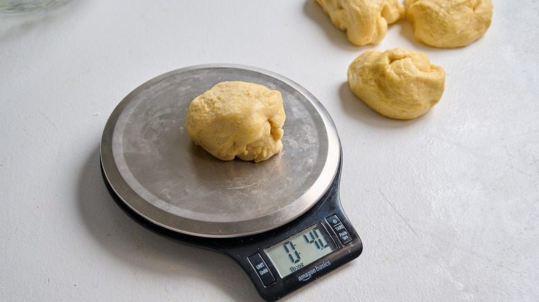 dough portioned into a 4 ounce ball on a scale
