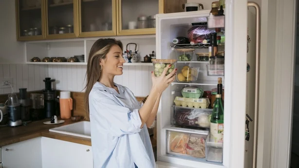 woman taking food out of fridge