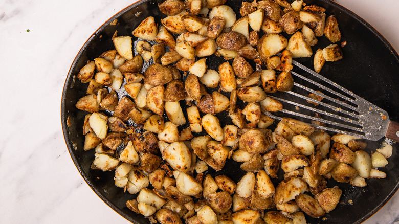 cast iron pan with potatoes and lardons