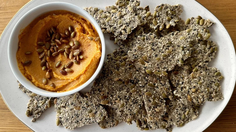 plate with seed crackers and pumpkin hummus