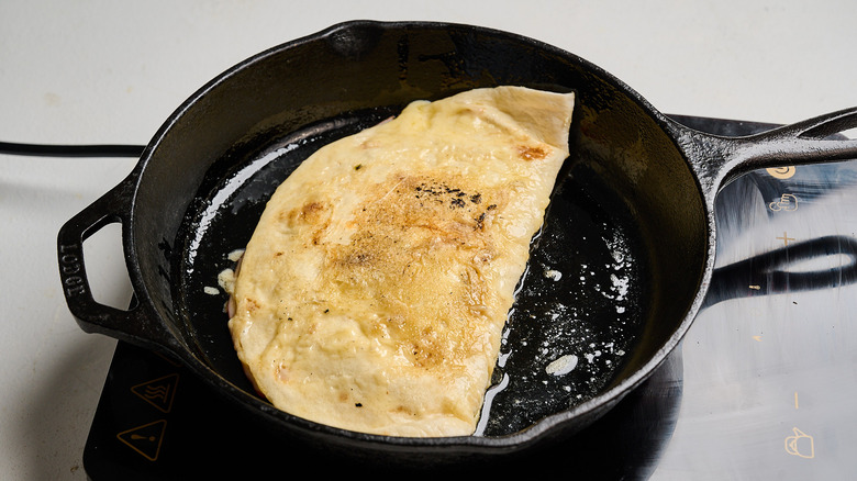 cooking quesadilla on opposite side in skillet