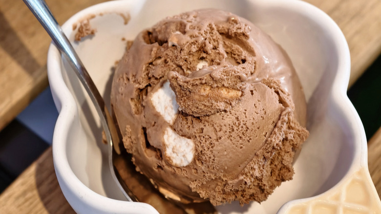 Rocky road ice cream in a white bowl with a spoon