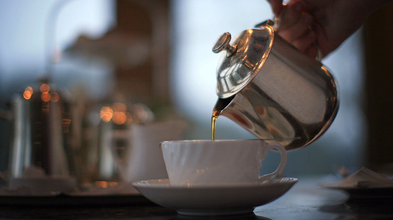 Person pouring a cup of tea
