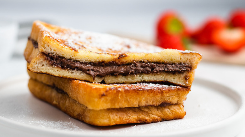 Nutella-stuffed French toast stacked on plate