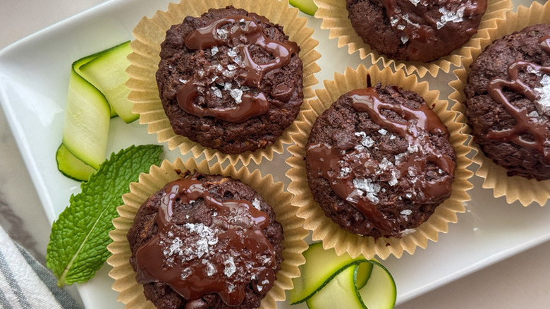 Chocolate zucchini muffins on white rectangular plate
