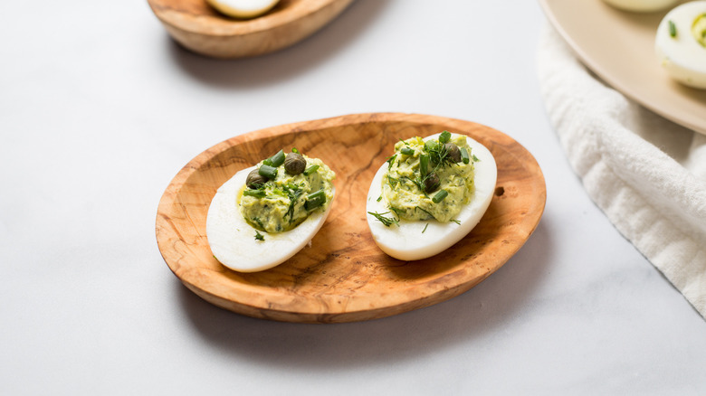 Green Goddess deviled eggs on wooden dish