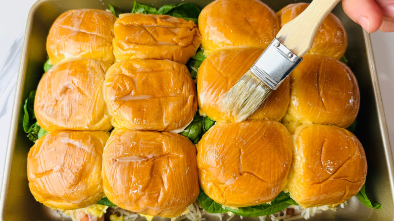 Pastry brush brushing butter onto buns