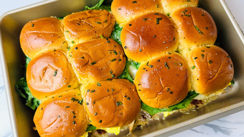 Sliders topped with chives in baking pan