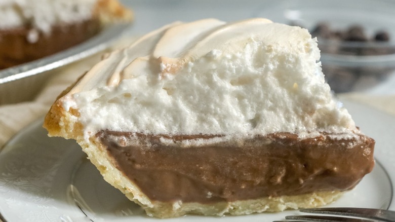 Close-up of chocolate meringue pie slice on white plate