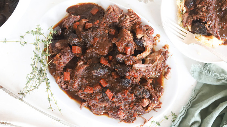 Herb and fig pot roast on a white plate