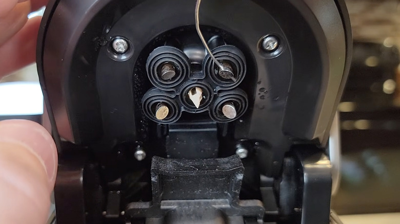 The underside of a Keurig machine top shows a needle.