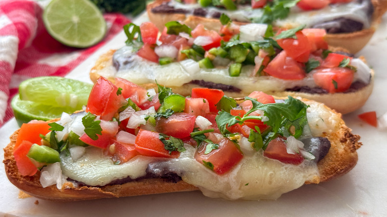 close up of molletes topped with pico de gallo