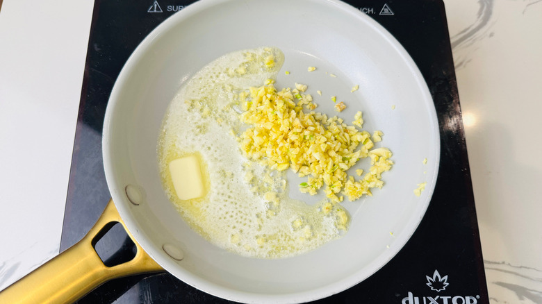 Melting butter and minced garlic in pan