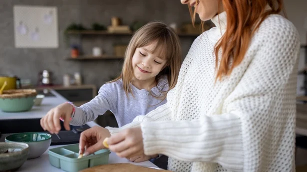 Mother and daughter preparing food