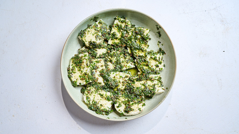 halloumi slices covered in zhug marinade on plate