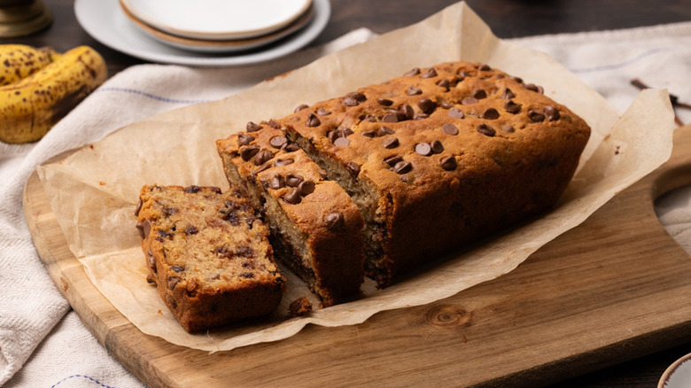 Sliced chai chocolate chip banana bread on a parchment-lined wooden board