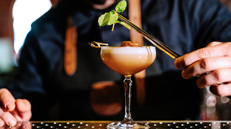 bartender garnishing a cocktail