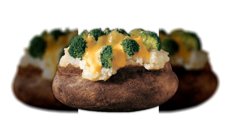 Cheese being poured over broccoli and baked potato