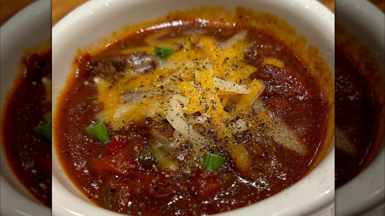 Outback Steakhouse Tasmanian chili on wood board beside spoon