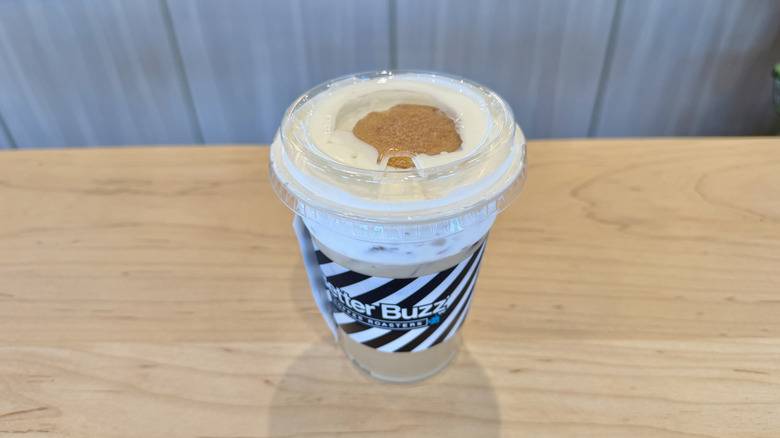 Better Buzz Banana Pudding Best Drink Ever served in a plastic cup with a wafer on a table