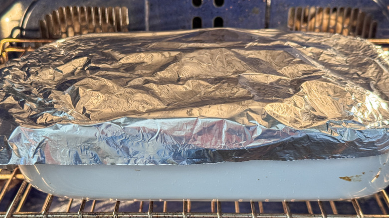 Foil covered baking dish in oven