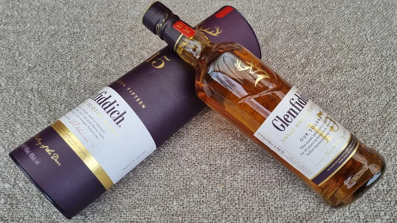 A top-down shot of a bottle of Glenfiddich 15-year balanced against its box