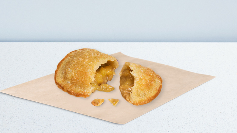 Taco Bell caramel apple empanada on a khaki napkin on a white counter