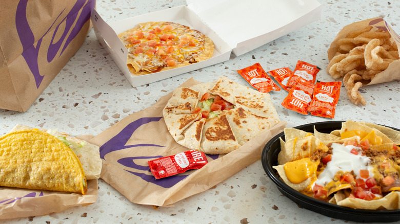 A bunch of Taco Bell menu items are displayed on a table.