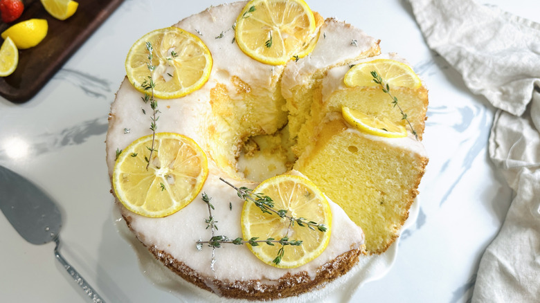 Lemon thyme chiffon cake on cake stand with slices cut
