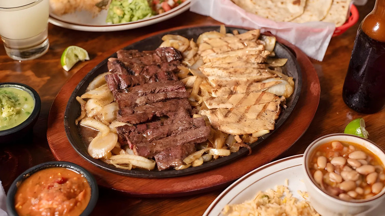 Plate of beef, chicken, and onion fajitas surrounded by assortment of Tex-Mex dishes at Teotihuacan Mexican Cafe
