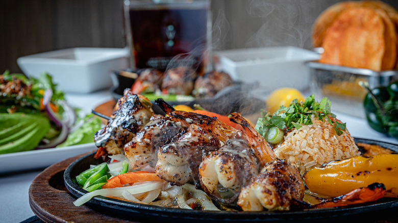 Plate of grilled shrimp, vegetables, and rice on restaurant table at Irma's Southwest in Houston