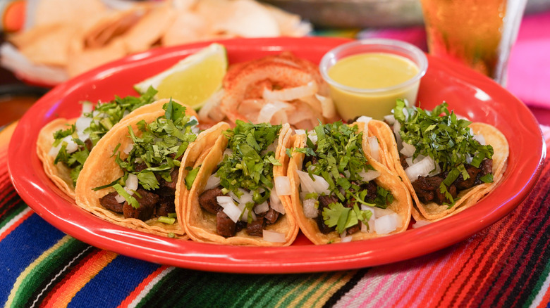 Plate of carne asada tacos, garnished with fresh cilantro