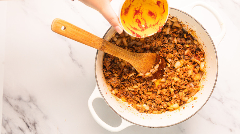 Adding tomato paste to meat sauce