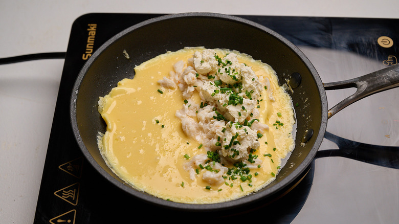 crab and boursin on top of egg in skillet