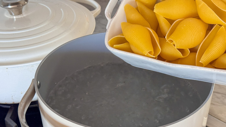 Pasta shells going in to pot of water