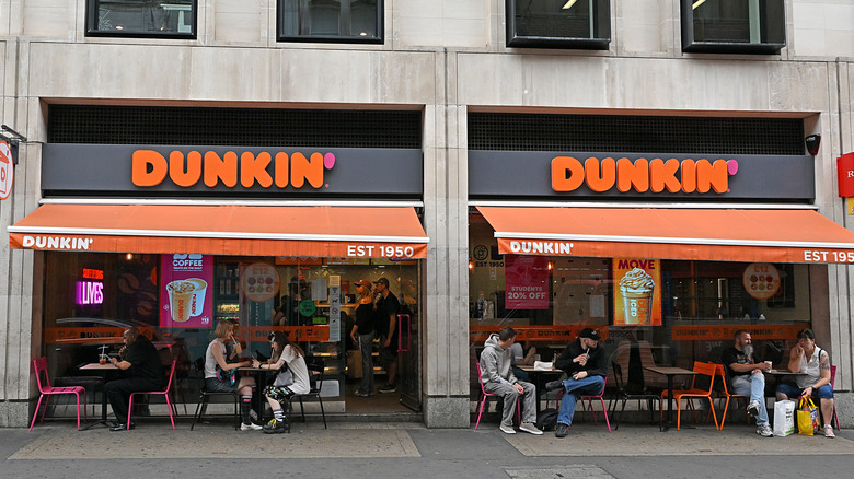 Diners at a Dunkin storefront.