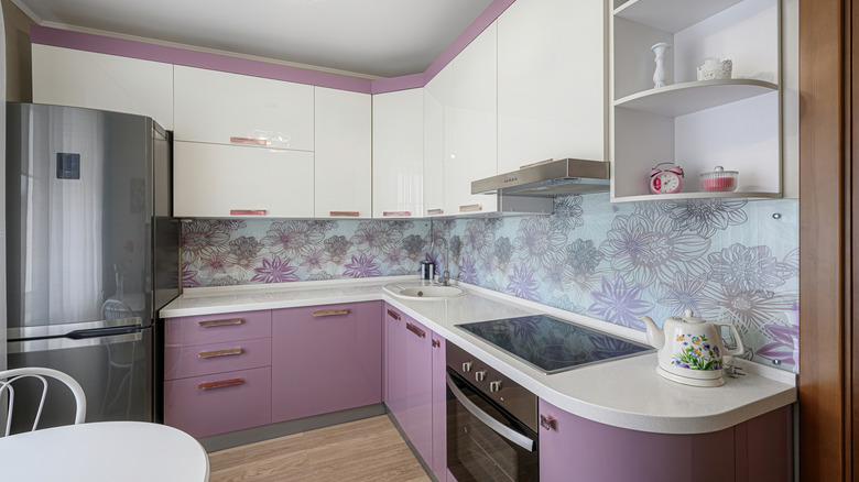 A kitchen with purple cabinets and a cream-colored laminate countertop